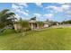 Spacious home with lush green lawn, palm trees, and a solar panel roof at 220 Escambia Dr, Winter Haven, FL 33884