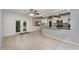 Open-concept living space with kitchen view, tiled floors, and light grey walls at 220 Escambia Dr, Winter Haven, FL 33884