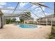 In-ground pool with screened enclosure and ladder, and tile trim at 220 Escambia Dr, Winter Haven, FL 33884