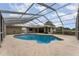 In-ground pool with screened enclosure, basketball hoop, and patio at 220 Escambia Dr, Winter Haven, FL 33884