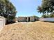 Wide view of the fenced backyard with grass, patio, and mature trees at 2201 Flamingo Ave, Deltona, FL 32738