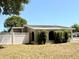 View of back exterior showing white fence and mature landscaping at 2201 Flamingo Ave, Deltona, FL 32738