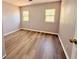 Cozy bedroom featuring wood-look floors, two windows, and neutral paint at 2201 Flamingo Ave, Deltona, FL 32738