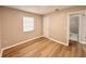 Bright bedroom featuring wood-look floors, a window, and a door to the ensuite bathroom at 2201 Flamingo Ave, Deltona, FL 32738