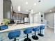 Kitchen island featuring a large countertop and stylish blue chairs that overlook the dining and living rooms at 9971 Highland Sky Aly, Orlando, FL 32832