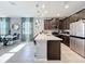 Modern kitchen boasts stainless steel appliances, a spacious island, and an open dining area at 9971 Highland Sky Aly, Orlando, FL 32832