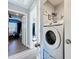 Convenient laundry area featuring a stacked washer and dryer unit with shelving for storage at 9971 Highland Sky Aly, Orlando, FL 32832