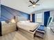 A primary bedroom features a custom accent wall, ceiling fan, and natural light at 9971 Highland Sky Aly, Orlando, FL 32832