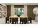 Modern dining room with a wooden table, black chairs, and large windows offering plenty of natural light at 1169 Hour Glass Rd, Lakeland, FL 33801