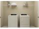 Functional laundry room with a washer, a dryer, and storage shelves above at 1169 Hour Glass Rd, Lakeland, FL 33801