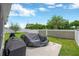 Spacious backyard with lush lawn, concrete patio, grill, and fenced perimeter for privacy at 305 St Georges Cir, Eagle Lake, FL 33839