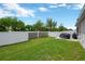 Expansive backyard with a grill, concrete patio, lush green lawn, and enclosed with a privacy fence at 305 St Georges Cir, Eagle Lake, FL 33839