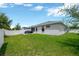 Spacious backyard with lush green grass, white fence, and patio area, perfect for outdoor activities and relaxation at 305 St Georges Cir, Eagle Lake, FL 33839
