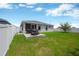 Clean backyard with a concrete patio, grill, well-maintained lawn, and privacy fencing at 305 St Georges Cir, Eagle Lake, FL 33839