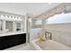 Modern bathroom featuring double sinks, dark cabinets, and a separate glass-enclosed shower and tub at 305 St Georges Cir, Eagle Lake, FL 33839