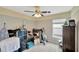 Bedroom with fan, cluttered with luggage, exercise equipment, and various storage items at 305 St Georges Cir, Eagle Lake, FL 33839