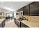Kitchen featuring a large island, dark cabinets, stainless steel appliances, and a dining space at 305 St Georges Cir, Eagle Lake, FL 33839