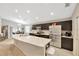 Open concept kitchen with island, stainless steel appliances, and dark wood cabinets at 305 St Georges Cir, Eagle Lake, FL 33839