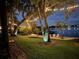 Charming backyard with string lights, a beach area, and waterfront views, perfect for relaxation at 5500 W Lake Butler Rd, Windermere, FL 34786