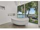 Luxury bathroom with standalone tub next to a large window with stunning waterfront views at 5500 W Lake Butler Rd, Windermere, FL 34786