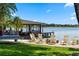 Relaxing beach area with chairs, a swing, and a covered dock providing a peaceful lakeside retreat at 5500 W Lake Butler Rd, Windermere, FL 34786