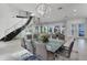 Elegant dining area with a glass table, seating for six, and a striking staircase with glass railing at 5500 W Lake Butler Rd, Windermere, FL 34786