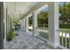 Relaxing covered front porch with hanging chair and stone tile flooring at 5500 W Lake Butler Rd, Windermere, FL 34786