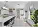 Contemporary kitchen features stainless appliances, a large island with seating, and a view to the outdoors at 5500 W Lake Butler Rd, Windermere, FL 34786