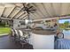 An outdoor kitchen has a bar with seating, TV and overlooks the water at 5500 W Lake Butler Rd, Windermere, FL 34786