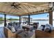 Beautiful covered outdoor living space with comfortable seating, dining area, and a stunning lake view at 5500 W Lake Butler Rd, Windermere, FL 34786