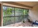 A screened balcony area with brick floors and iron railing overlooking lush green landscaping at 7759 Sugar Bend Dr # 7759, Orlando, FL 32819