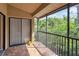 A screened balcony with a sliding glass door, and view of lush, green landscaping at 7759 Sugar Bend Dr # 7759, Orlando, FL 32819