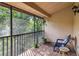 View of a balcony area with brick floors and iron railing overlooking lush green landscaping at 7759 Sugar Bend Dr # 7759, Orlando, FL 32819