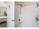 Bathroom featuring a white tiled tub/shower with updated shower fixtures, open to bedroom at 7759 Sugar Bend Dr # 7759, Orlando, FL 32819