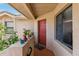 Covered entrance area featuring a red front door, exterior window, and a variety of plants at 7759 Sugar Bend Dr # 7759, Orlando, FL 32819