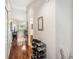 Hallway with hardwood flooring, shoe rack, and view of living area with balcony and bathroom at 7759 Sugar Bend Dr # 7759, Orlando, FL 32819