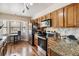 Efficient kitchen with stainless steel appliances, granite counters, and ample wood cabinets at 7759 Sugar Bend Dr # 7759, Orlando, FL 32819
