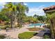 Community pool area surrounded by mature palm trees, lush landscape, and lounge chairs at 7759 Sugar Bend Dr # 7759, Orlando, FL 32819
