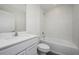 Well-lit bathroom with a sleek vanity, commode and bathtub-shower combination featuring white tiles at 181 Cimarron Ln, Poinciana, FL 34759