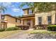 Charming two-story home with stucco exterior and landscaped front yard with brick pathway at 140 Napoli Dr, Davenport, FL 33897