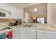 Well-lit kitchen with white appliances and a pass-through to the living area at 140 Napoli Dr, Davenport, FL 33897