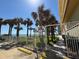 Gated access to the beach with palm trees, a grassy area, and designated parking spaces offer convenience and security at 2300 N Atlantic Ave # 1502, Daytona Beach, FL 32118