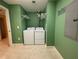Laundry room featuring a washing machine and dryer with shelving for storage, complete with tiled flooring at 2300 N Atlantic Ave # 1502, Daytona Beach, FL 32118