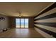 Open living space boasting laminate floors, striped accent wall, and large sliding doors to an ocean view at 2300 N Atlantic Ave # 1502, Daytona Beach, FL 32118
