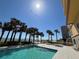 A sparkling outdoor pool with palm trees and ocean views creates a serene setting for relaxation and recreation at 2300 N Atlantic Ave # 1502, Daytona Beach, FL 32118