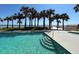Community pool with crystal-clear water, palm trees, and ocean views at 2300 N Atlantic Ave # 1502, Daytona Beach, FL 32118