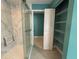 Walk-in shower with glass doors featuring a built-in seat and storage shelves in the adjacent room at 2300 N Atlantic Ave # 1502, Daytona Beach, FL 32118