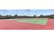 Outdoor tennis courts with players, red court surface, dark green perimeter, and shade netting at 4536 Ochos Rios Pl, Kissimmee, FL 34758