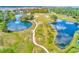 Scenic aerial of the community golf course with lake views, green fairways and trees at 518 Cortez Dr, Davenport, FL 33837