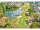 Scenic aerial view of a property adjacent to a golf course and pond, highlighting the lush, recreational surroundings at 518 Cortez Dr, Davenport, FL 33837